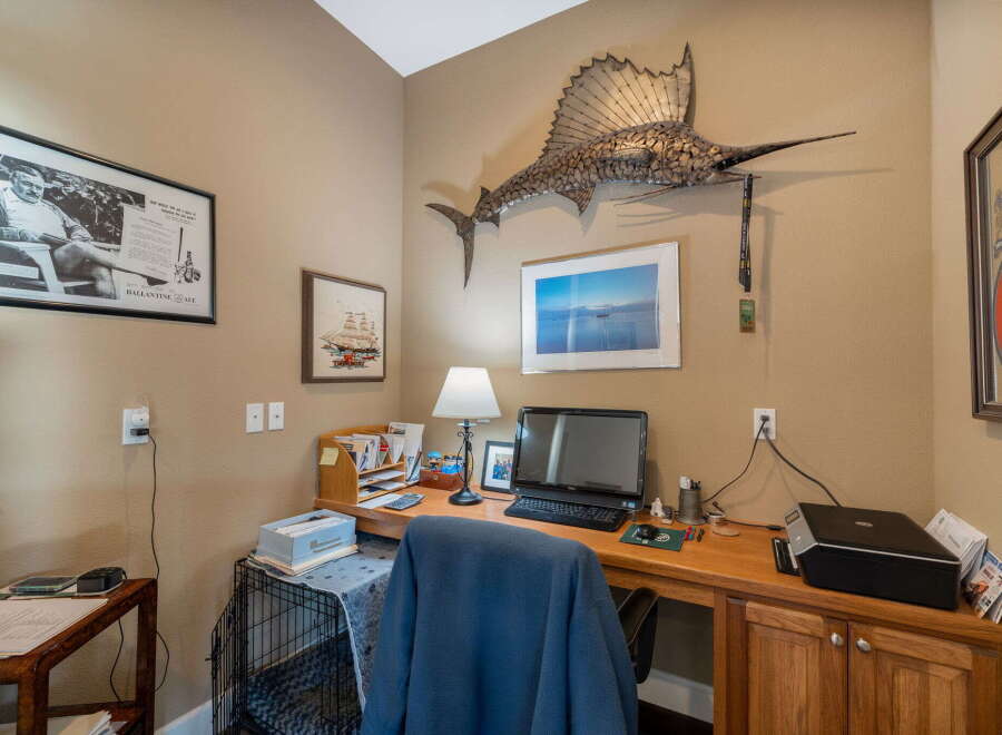 This home office features a spacious wooden desk equipped with a computer, printer, and lamp, perfect for productivity.
