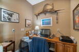 This home office features a spacious wooden desk equipped with a computer, printer, and lamp, perfect for productivity.