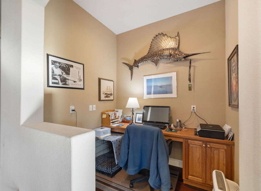 This home office features a spacious wooden desk equipped with a computer, lamp, and printer, perfect for productivity.