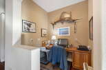 This home office features a spacious wooden desk equipped with a computer, lamp, and printer, perfect for productivity.