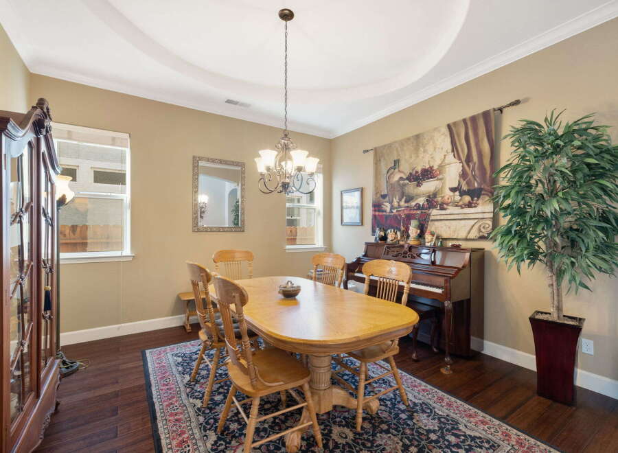 This elegant dining room features a large wooden dining table with six chairs, perfect for family gatherings.