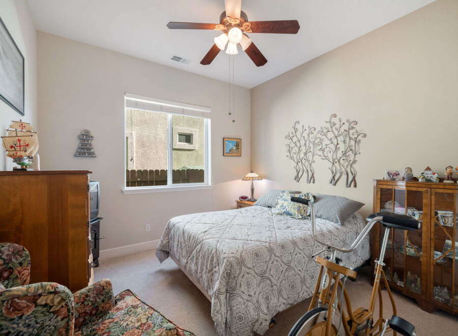 This charming bedroom features a comfortable queen-size bed adorned with a decorative quilt and accent pillows, perfect for a restful night's sleep.