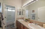 This bright bathroom features a spacious vanity with dual sinks and ample counter space, perfect for busy mornings.