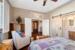 Experience comfort and style in this inviting bedroom, featuring a plush armchair with patriotic pillows and a cozy bed adorned with a nature-themed quilt.