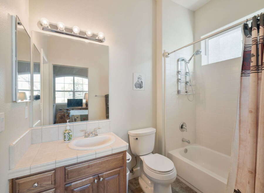 This bathroom features a spacious vanity with a tiled countertop and ample storage, perfect for organizing your essentials.