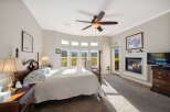 Experience luxury and comfort in this stunning master bedroom, featuring a grand four-poster bed and a cozy fireplace perfect for chilly evenings.