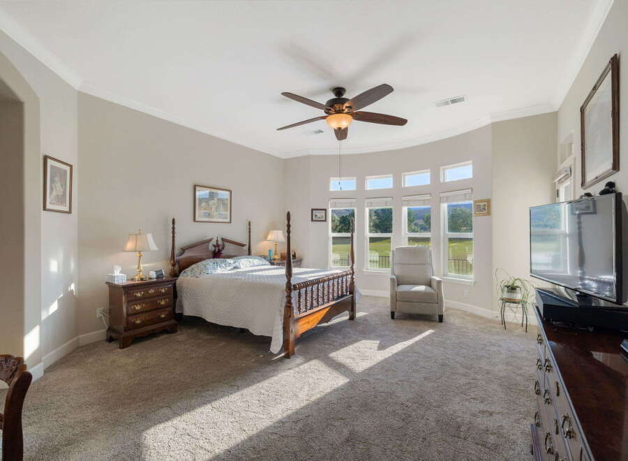 This spacious bedroom offers a luxurious retreat with a comfortable king-sized bed and a cozy armchair.