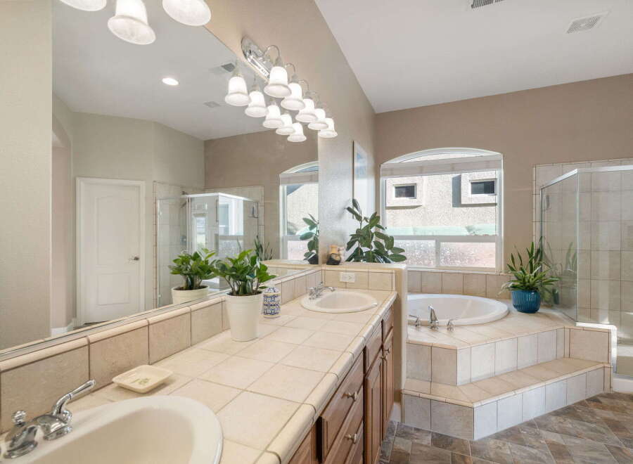Indulge in luxury with this stunning master bathroom, featuring a spacious dual vanity with ample counter space and a large, inviting soaking tub.