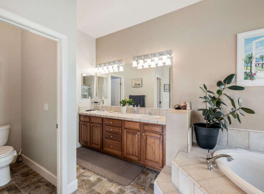 This spacious bathroom features a double vanity with ample storage and a large mirror, perfect for busy mornings.