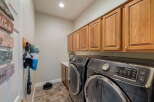 This laundry room boasts ample storage with beautiful wooden cabinets lining the walls, perfect for organizing all your laundry essentials.