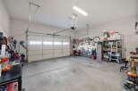This spacious garage offers ample storage solutions, including a tall shelving unit and a filing cabinet, perfect for organizing tools and equipment.
