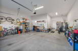 This spacious garage offers ample storage solutions with multiple shelving units, perfect for organizing tools, sports equipment, and seasonal items.