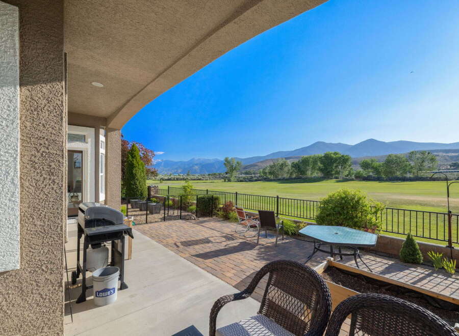 Enjoy outdoor living with this spacious patio featuring a grill, dining table, and comfortable seating, perfect for entertaining.