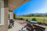 Enjoy outdoor living with this spacious patio featuring a grill, dining table, and comfortable seating, perfect for entertaining.