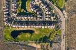 Experience luxury living in this stunning aerial view of a master-planned community, featuring a pristine golf course with a serene water feature.