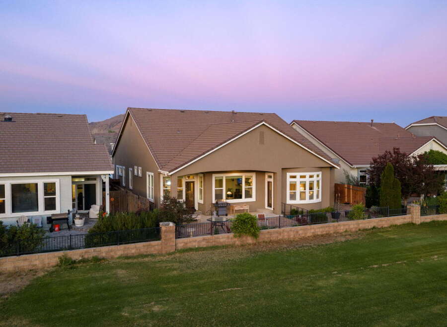 This stunning home features a spacious backyard perfect for entertaining, complete with a patio area and a grill.