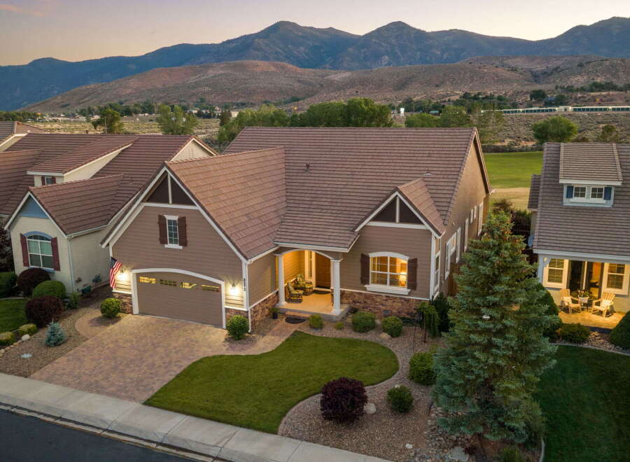 Experience luxury living in this stunning home, boasting a beautifully landscaped yard and a welcoming front porch perfect for enjoying the evening air.