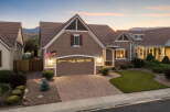 This stunning home features a beautifully landscaped front yard with a lush green lawn and mature shrubs, leading to a welcoming entryway.