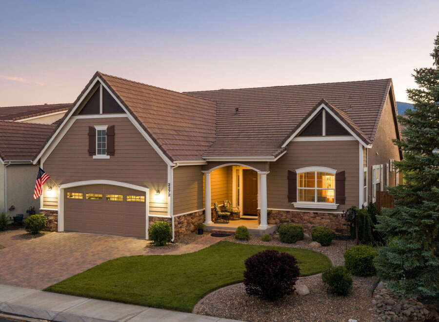 This charming home features a welcoming front porch with seating, perfect for enjoying the evening air.