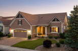 This charming home features a welcoming front porch with seating, perfect for enjoying the evening air.