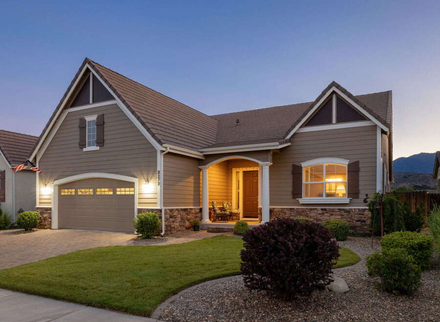 This charming home features a welcoming covered front porch with seating, perfect for enjoying the evening air.