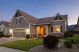 This charming home features a welcoming covered front porch with seating, perfect for enjoying the evening air.