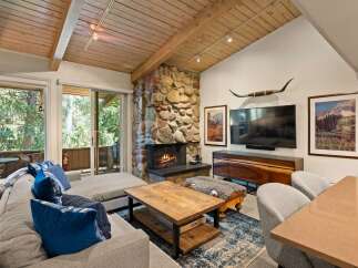 Experience rustic charm in this inviting living room, featuring a magnificent stone fireplace as the centerpiece.