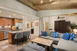 Experience modern living in this open-concept space featuring a gourmet kitchen with rich wood cabinetry and a large island perfect for entertaining.