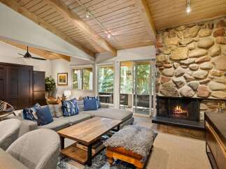 Cozy living room featuring a large stone fireplace and a comfortable sectional sofa, perfect for relaxing evenings.