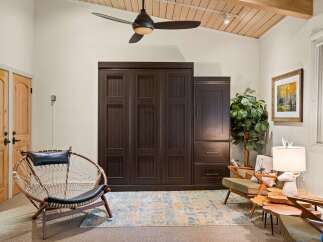 Discover this inviting living space featuring a large, dark wood murphy bed system, perfect for maximizing room utility.
