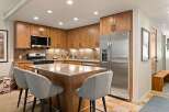 This modern kitchen boasts beautiful natural wood cabinetry and a sleek stainless steel refrigerator.