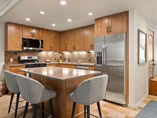 This modern kitchen boasts beautiful natural wood cabinetry and a sleek stainless steel refrigerator.