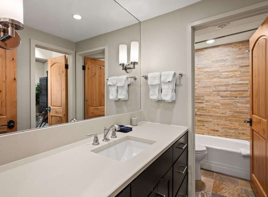 Experience luxury in this beautifully appointed bathroom featuring a sleek vanity with a modern sink and chrome fixtures.
