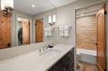 Experience luxury in this beautifully appointed bathroom featuring a sleek vanity with a modern sink and chrome fixtures.