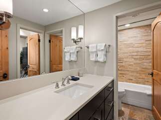 Experience luxury in this beautifully appointed bathroom featuring a sleek vanity with a modern sink and chrome fixtures.