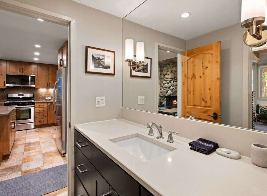 This beautifully appointed bathroom features a modern vanity with a sleek countertop and undermount sink, complemented by elegant brushed nickel fixtures.
