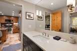 This beautifully appointed bathroom features a modern vanity with a sleek countertop and undermount sink, complemented by elegant brushed nickel fixtures.