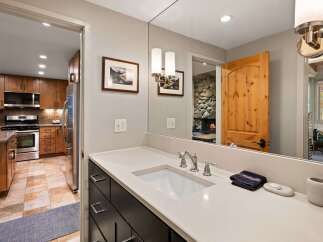 This beautifully appointed bathroom features a modern vanity with a sleek countertop and undermount sink, complemented by elegant brushed nickel fixtures.