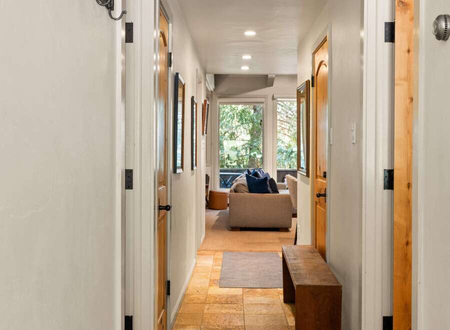 Step into this charming hallway featuring warm wooden doors and a rustic bench, perfect for a welcoming entryway.