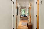 Step into this charming hallway featuring warm wooden doors and a rustic bench, perfect for a welcoming entryway.