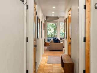 Step into this charming hallway featuring warm wooden doors and a rustic bench, perfect for a welcoming entryway.
