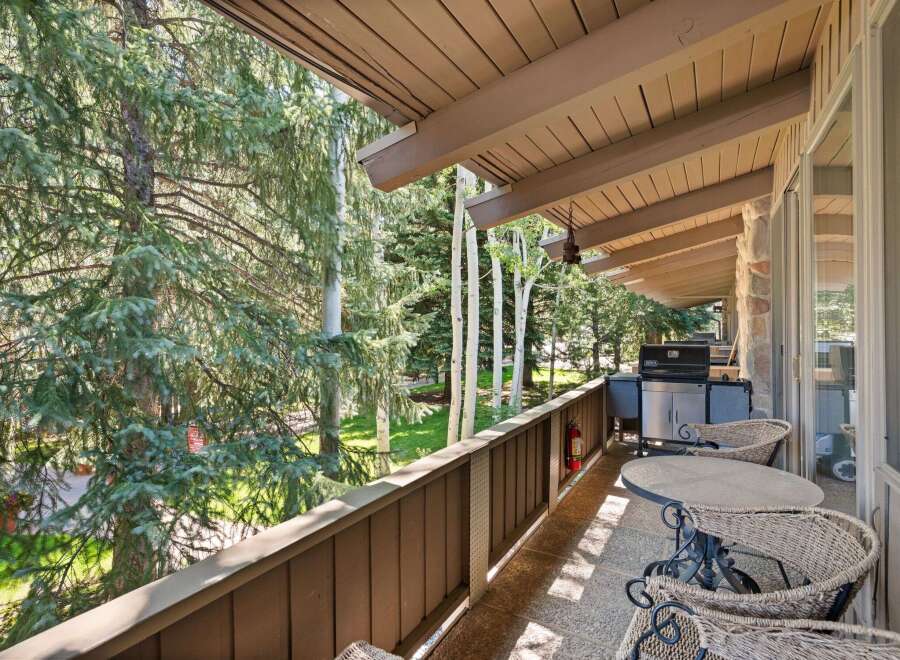 Enjoy outdoor living on this spacious balcony, perfect for entertaining or relaxing amidst the serene forest views.