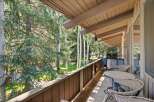 Enjoy outdoor living on this spacious balcony, perfect for entertaining or relaxing amidst the serene forest views.