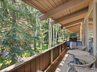 Enjoy outdoor living on this spacious balcony, perfect for entertaining or relaxing amidst the serene forest views.