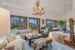 Experience luxurious mountain living in this stunning living and dining area, featuring a grand antler chandelier and expansive windows with breathtaking views.