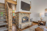 Experience rustic charm and modern comfort in this inviting living space, featuring a magnificent stone fireplace with a rustic wood mantel, perfect for cozy evenings.