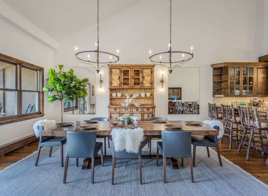 This spacious dining room features a large wooden table with comfortable grey chairs, perfect for hosting gatherings.