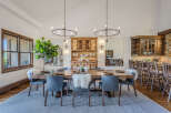This spacious dining room features a large wooden table with comfortable grey chairs, perfect for hosting gatherings.