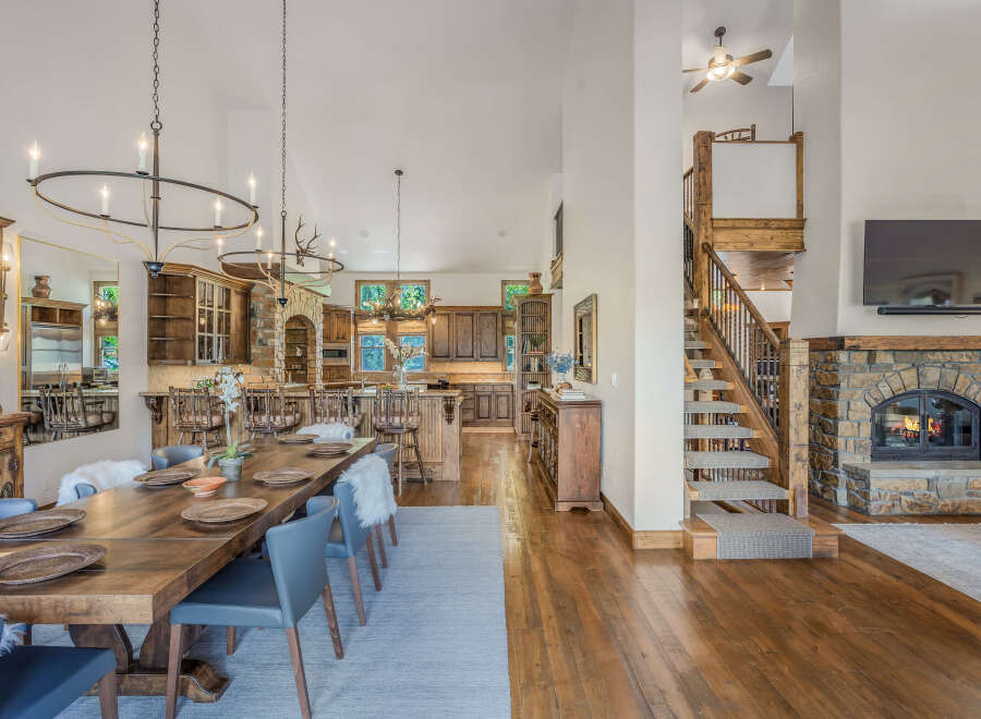 Experience rustic elegance in this spacious dining and living area, featuring a grand wooden dining table set for intimate gatherings.