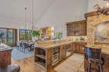 Experience rustic elegance in this stunning mountain home, featuring a gourmet kitchen with custom wood cabinetry, granite countertops, and a wine cooler.